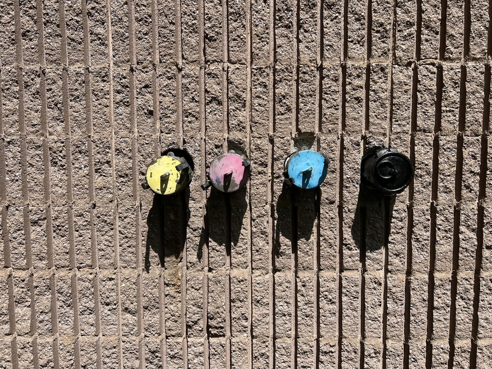 Four existing color-coded exterior ink fill connections before the spill-containment upgrade