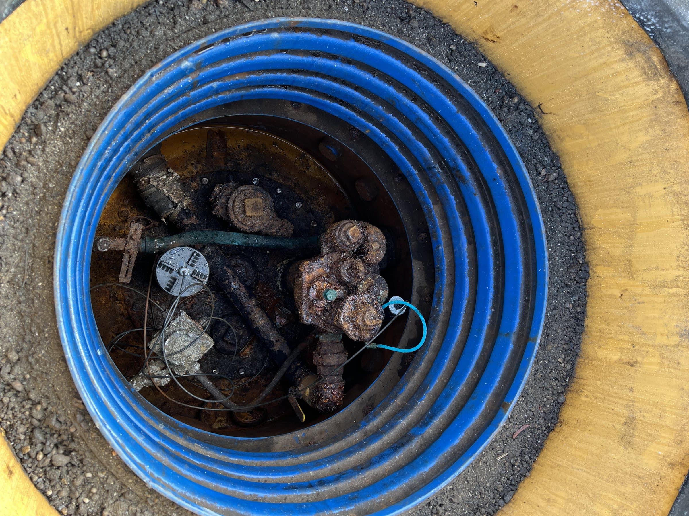 Open tank sump with piping connections and monitoring equipment.