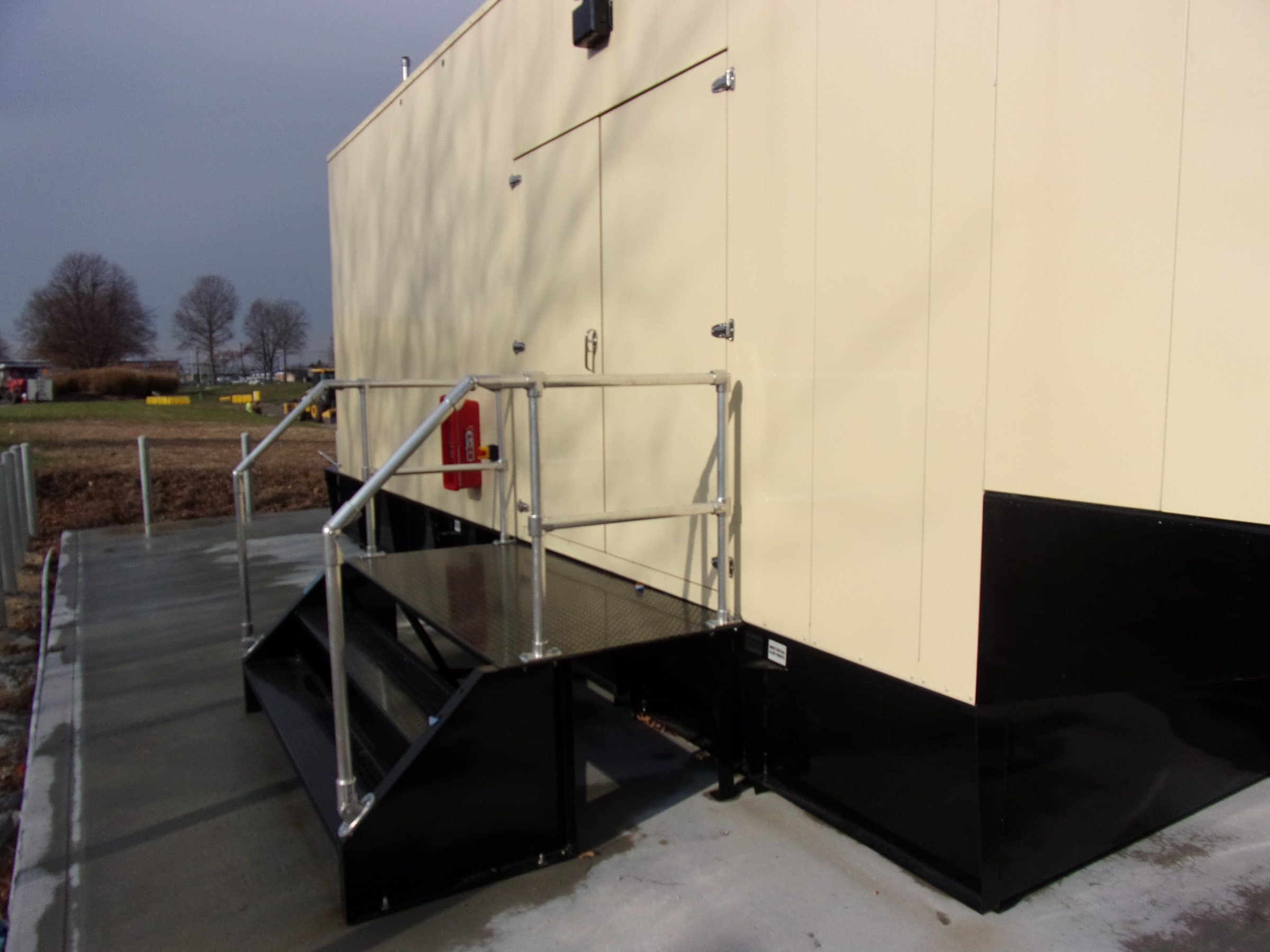 Aboveground tank enclosure with access platform and handrails.