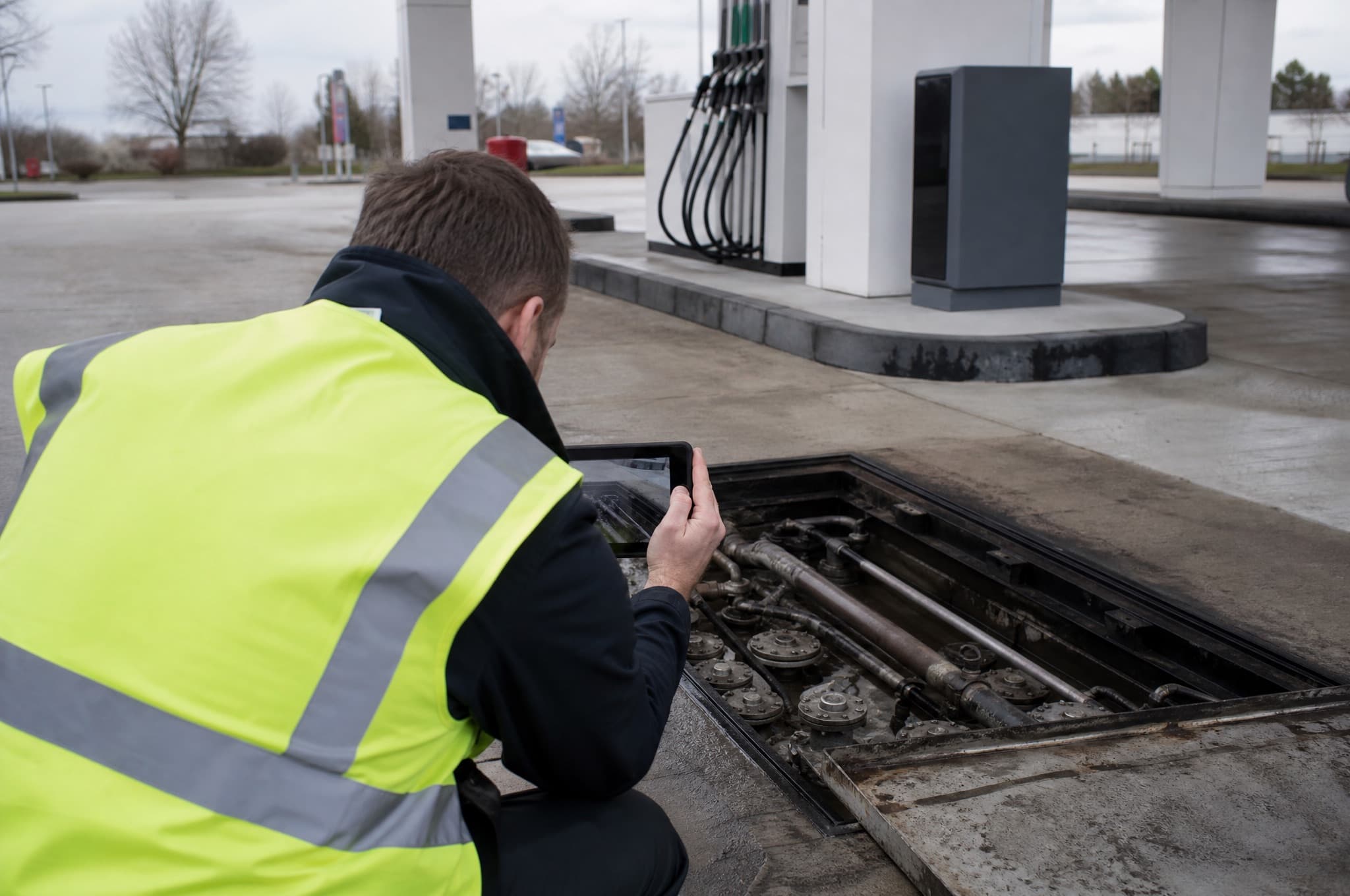 Fuel-system specialist reviewing drawings with a contractor on a tank installation site
